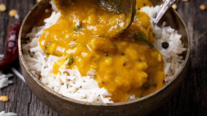 Pouring Gujarati dal over rice.