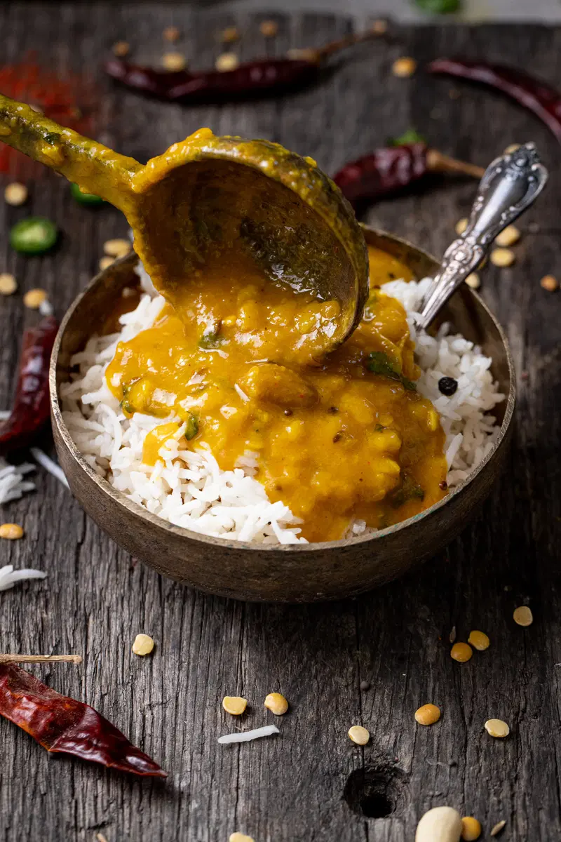 Pouring Gujarati dal over rice.