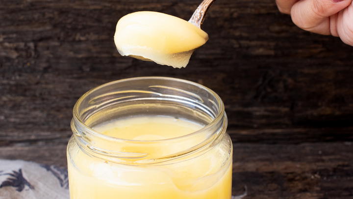 Spooning out ghee from a jar