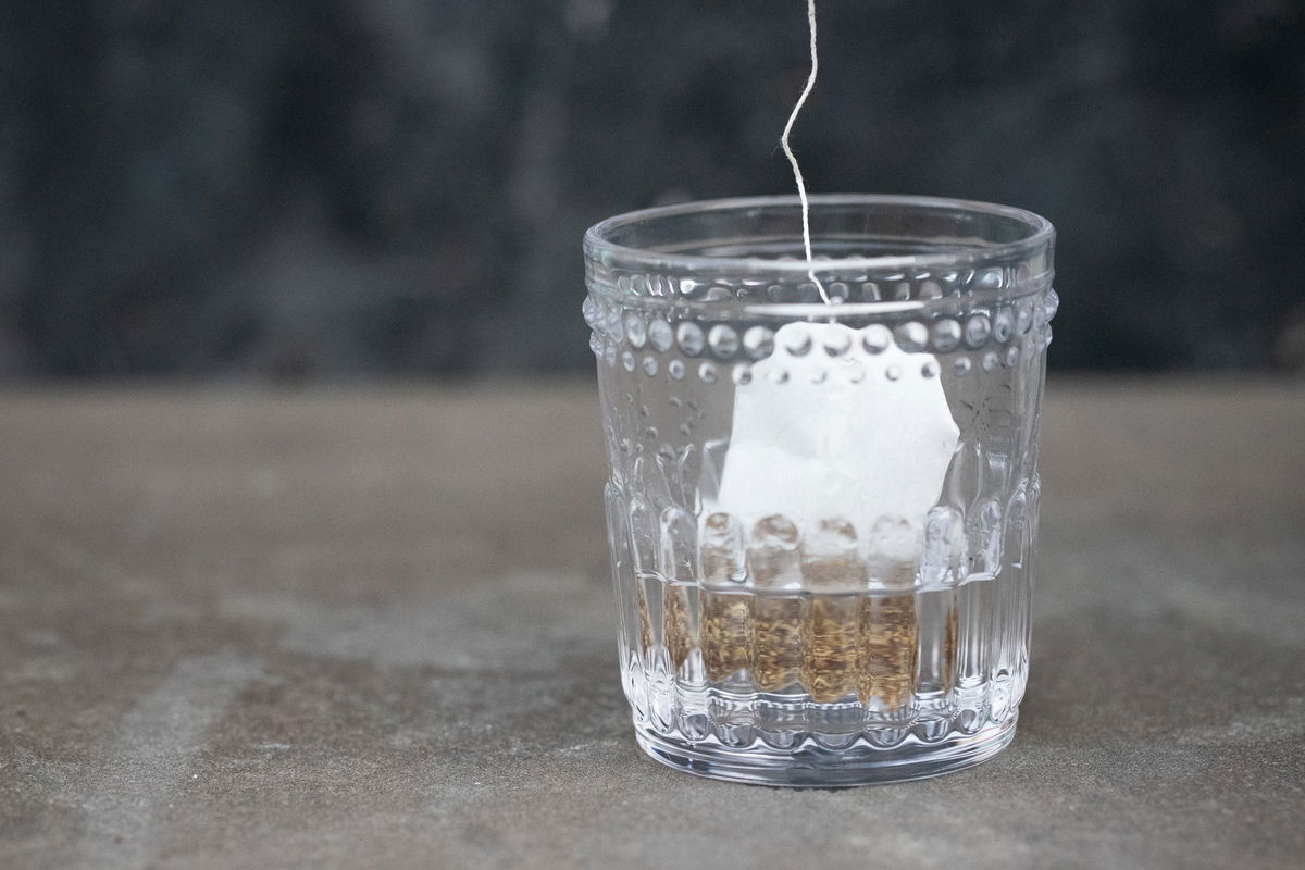 Steeping licorice tea bag in gin