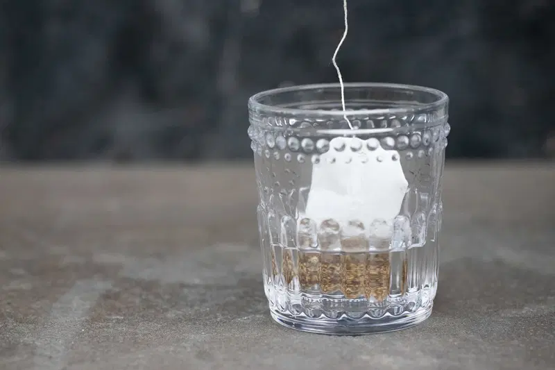 Steeping licorice tea bag in gin