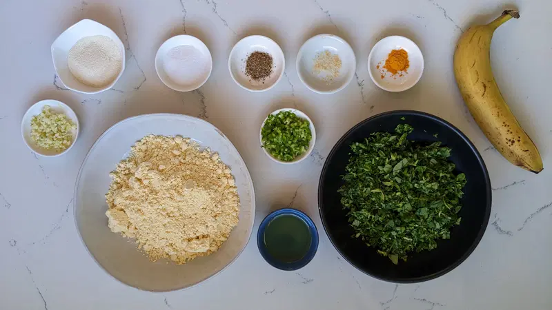 Methi na gota ingredients: besan, fenugreek leaves, banana, rava, salt, turmeric, black pepper, green chilies, garlic, hing