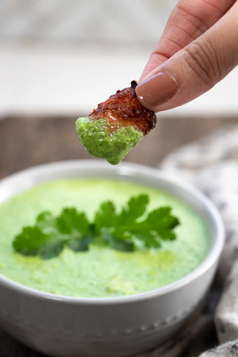 Chicken tikka bite dipped in cilantro yogurt chutney