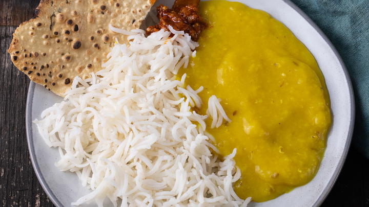 A plate of dal chawal with some papdi