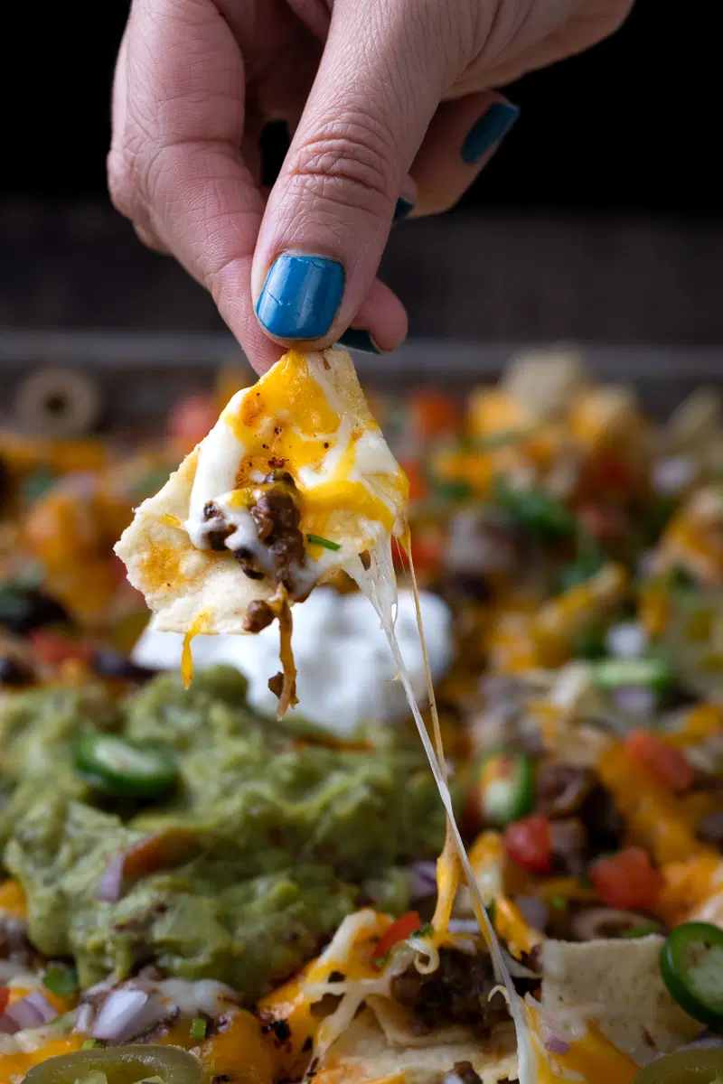 Holding a chip from the dal makhani nachos