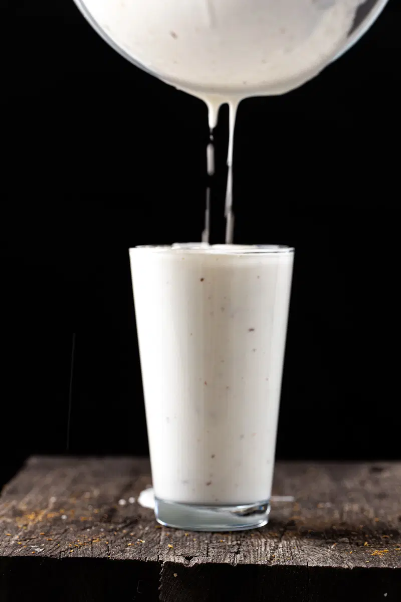 Pouring the salt lassi into the glass