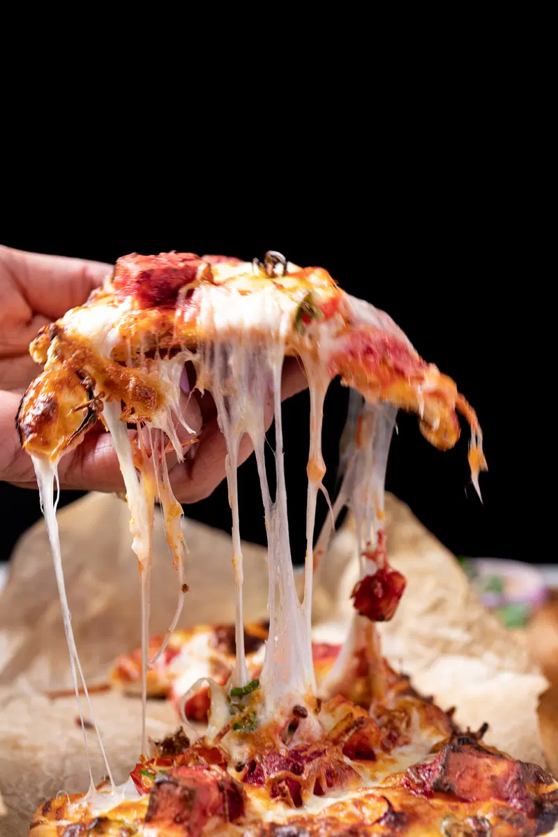 Cheese pull of paneer tikka pizza