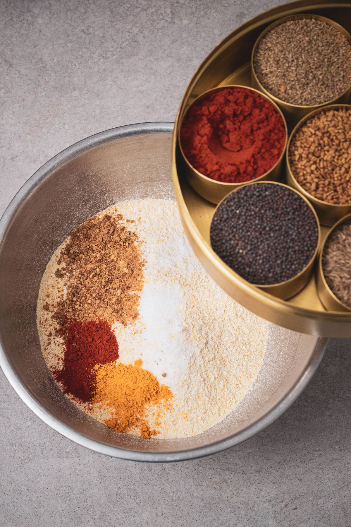 Dry ingredients for handvo: hanvo flour, turmeric, chili powder, dhana jeeru.