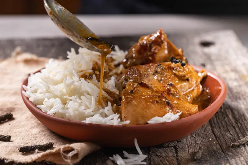 Spooning on the long pepper chicken.