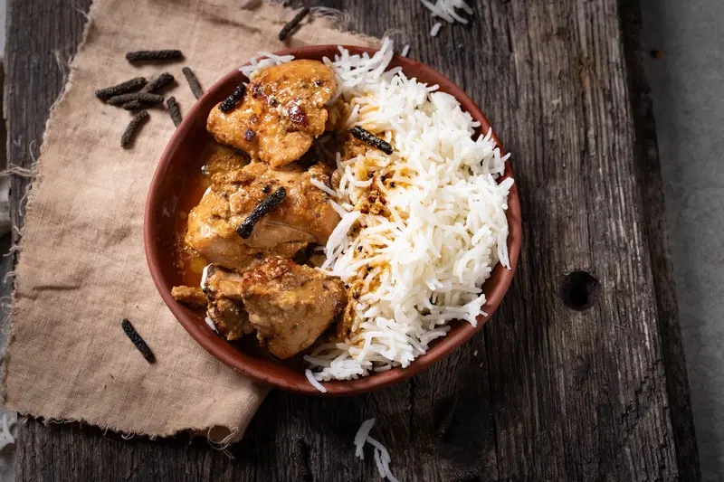 Bowl of long pepper chicken served with rice.