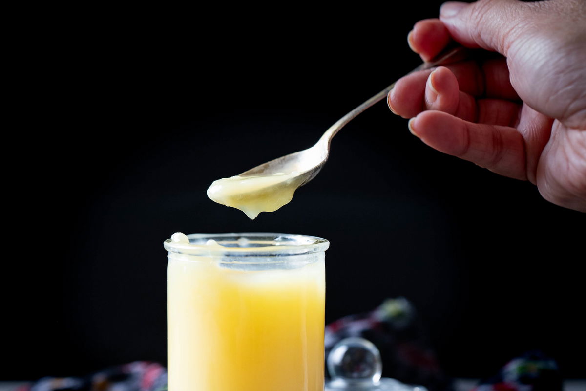 Spooning some ghee from the jar