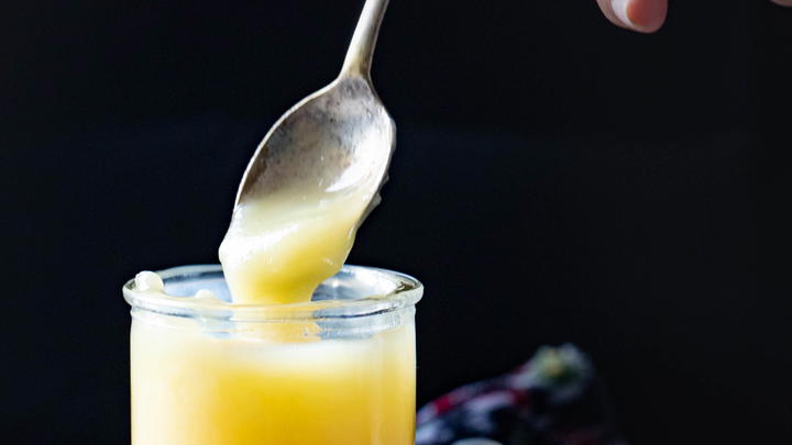 Spooning some ghee from a jar