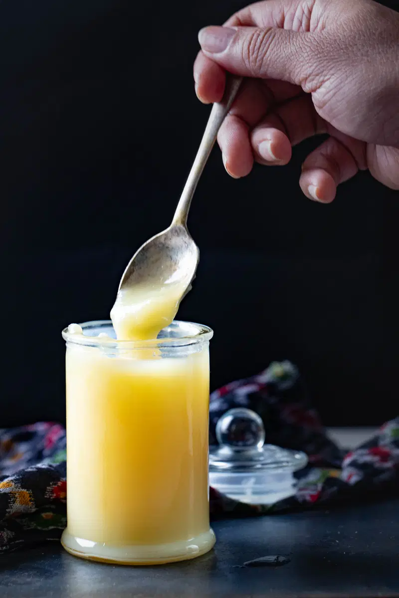 Spooning some ghee from a jar