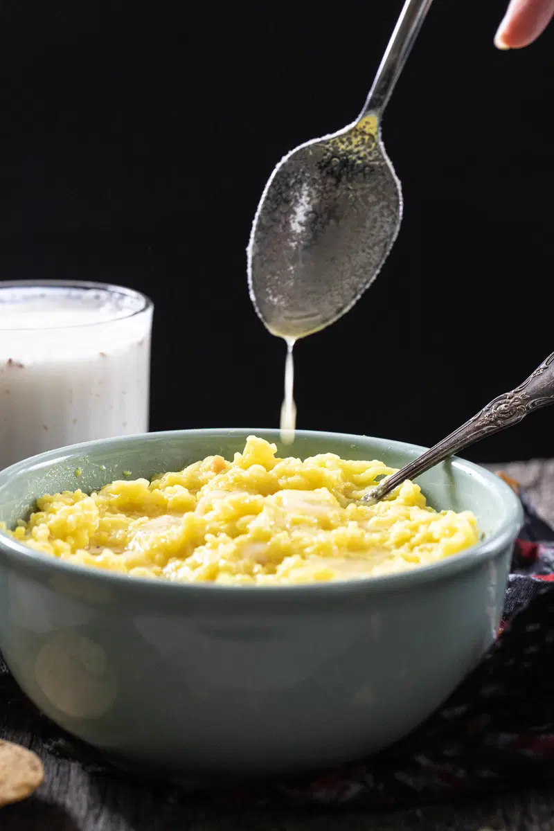 Drizzling ghee over khichdi.