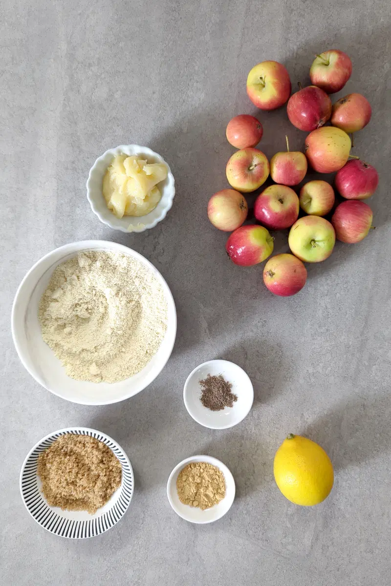 Ingredients of Baked Apples: ghee, apples, almond flour, cardamom powder, brown sugar, ginger, and a lemon.