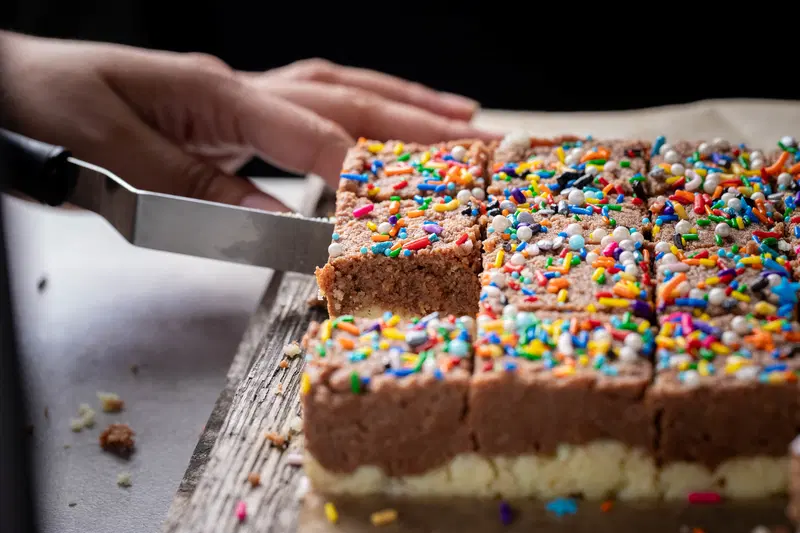 Taking a piece of chocolate barfi with an offset spatula.