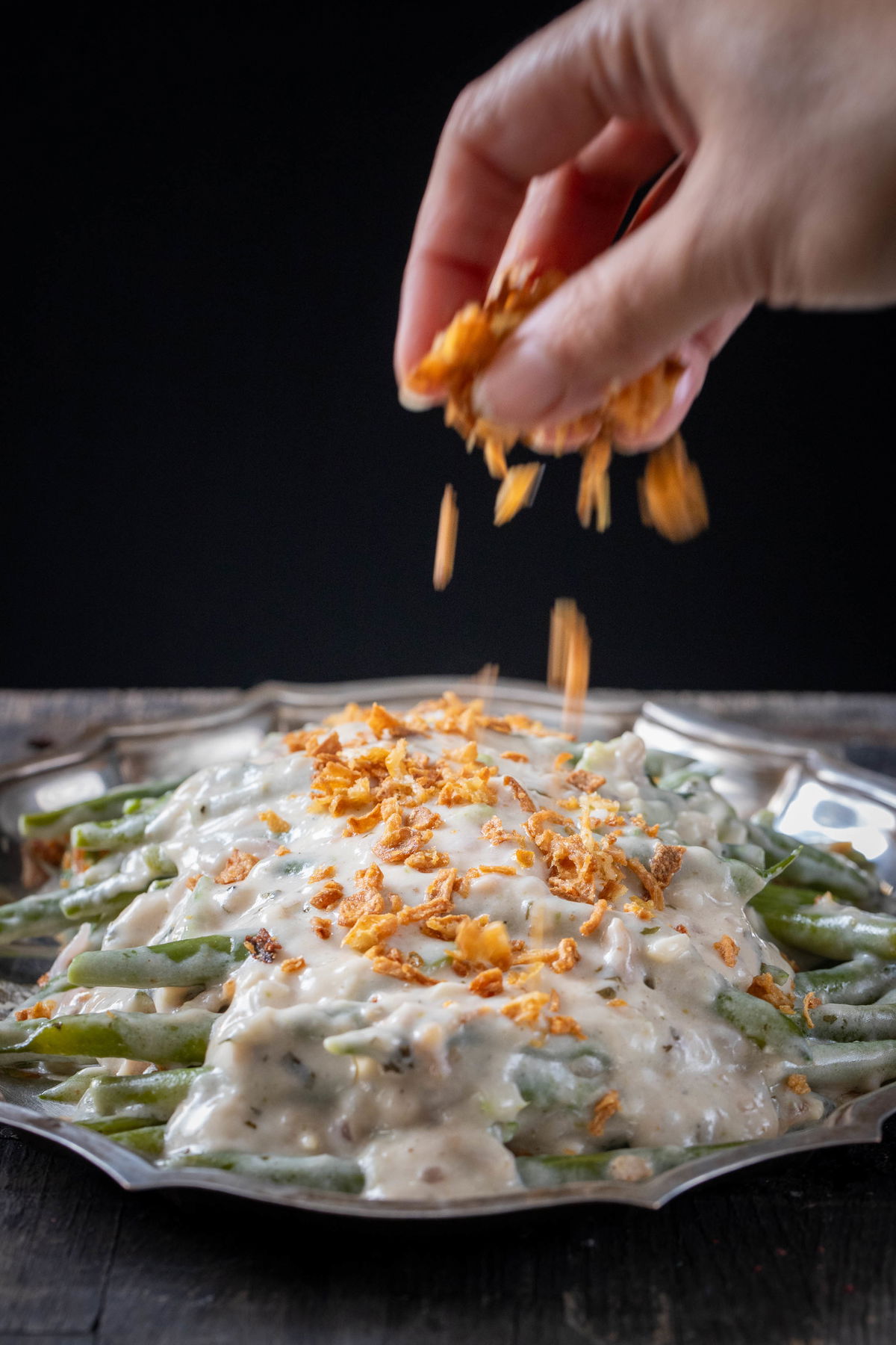 Topping methi malai green beans with fried onions.