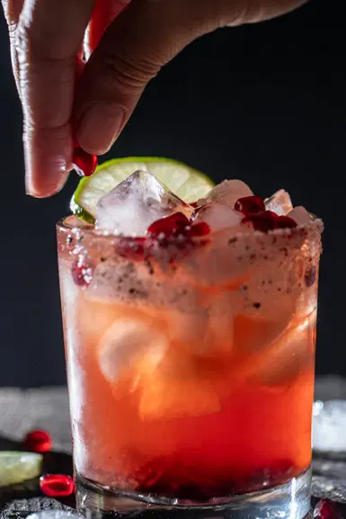Dropping an aril on a pomegranate margarita