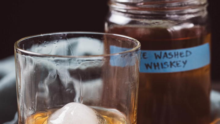 Ghee Washed Whiskey showing a glass and the jar.