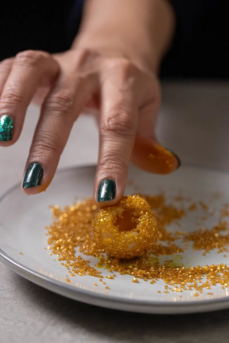 Coat the lychees in gold crystals.