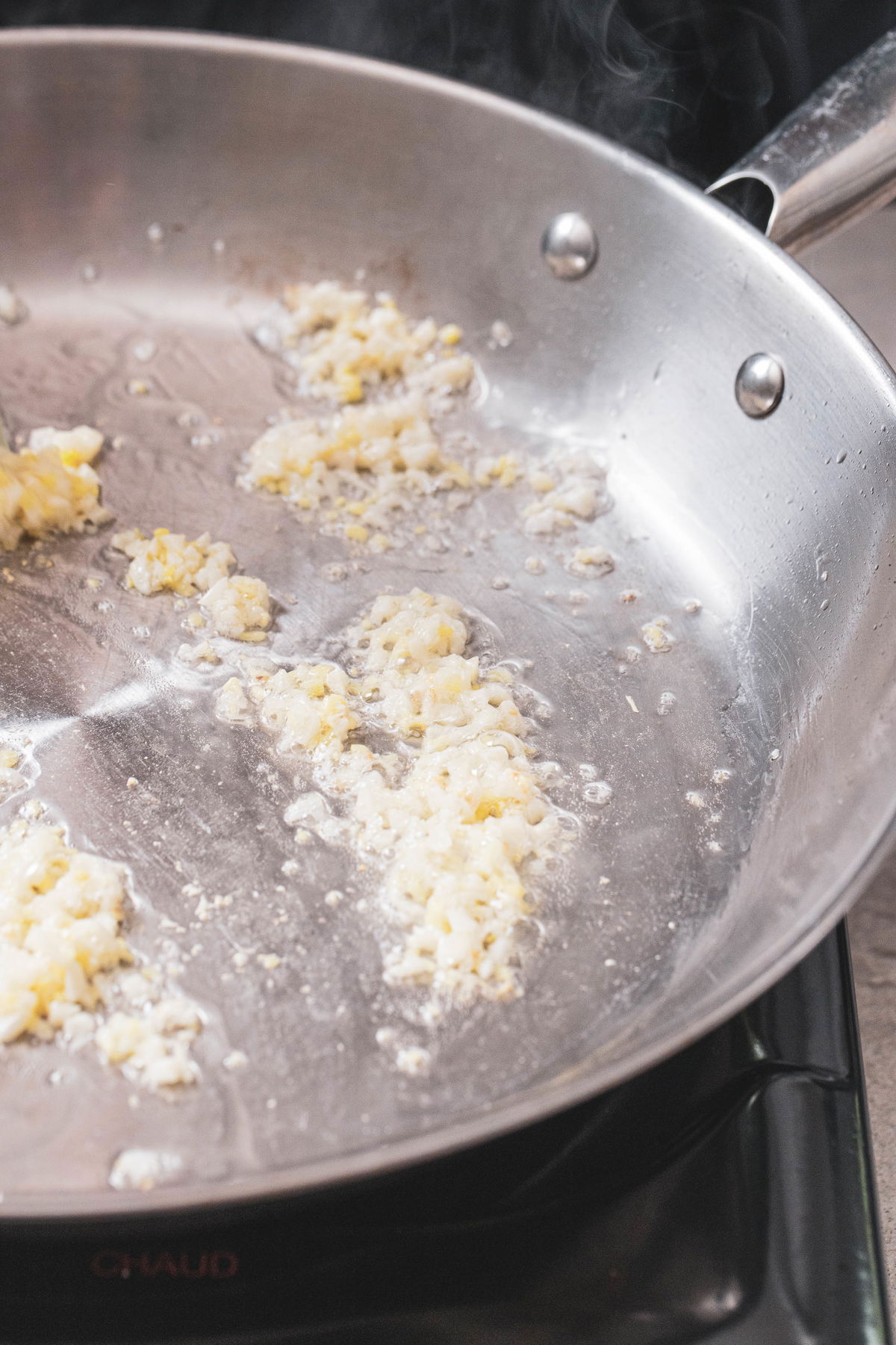 Heat oil, ginger, and garlic in a pan.