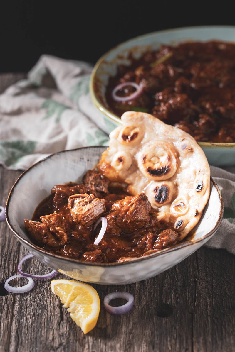 Bowl of lamb bhuna served with naan.