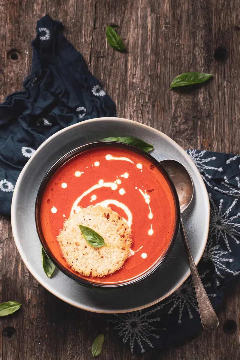 Top view of tomato soup with cream swirl.