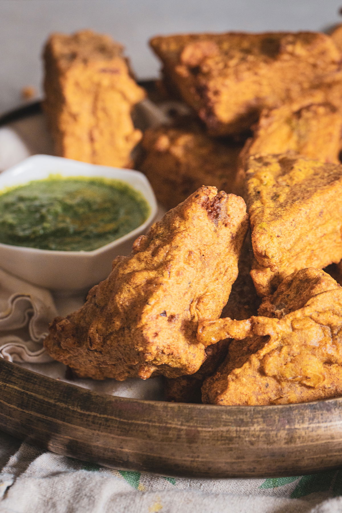 A close up shot of bread pakora showing the green chutney.