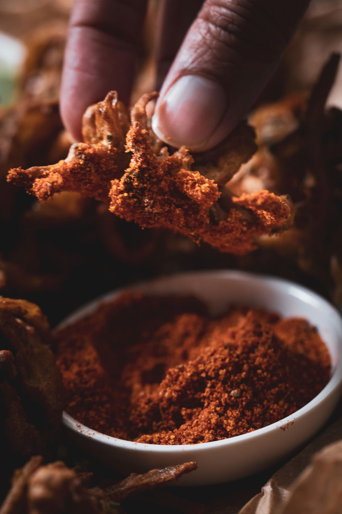 Holding a kanda bhaji over chutney