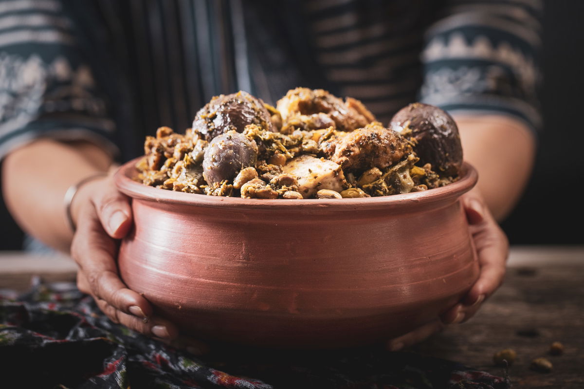 Holding the pot of Surti Undhiyu