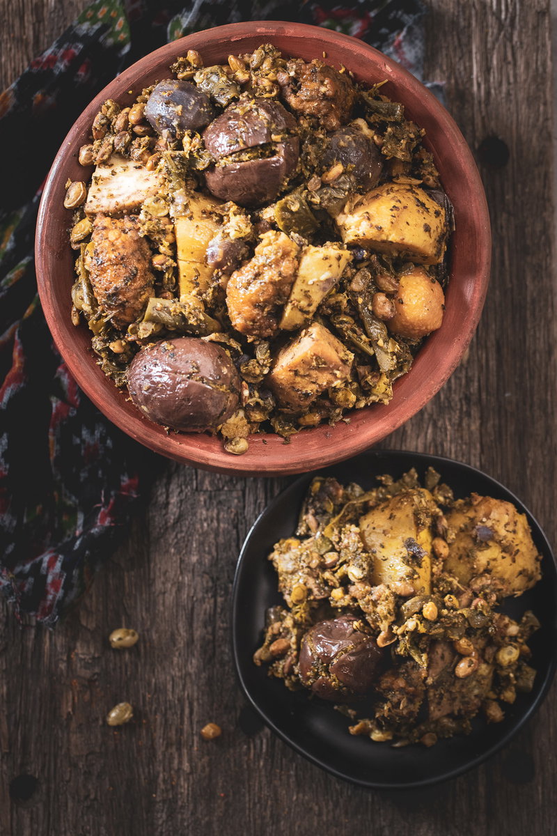 Top shot of Surti Undhiyu next to a serving on a plate.
