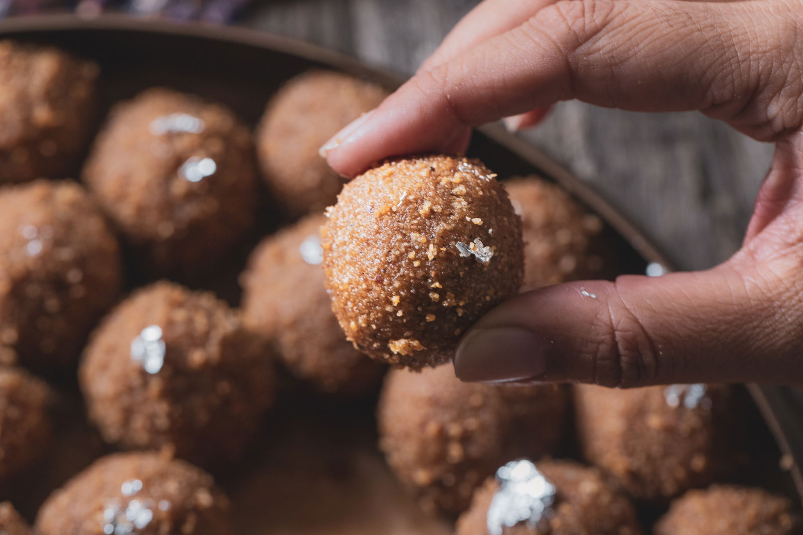 Puja holding out a choorma ladoo.