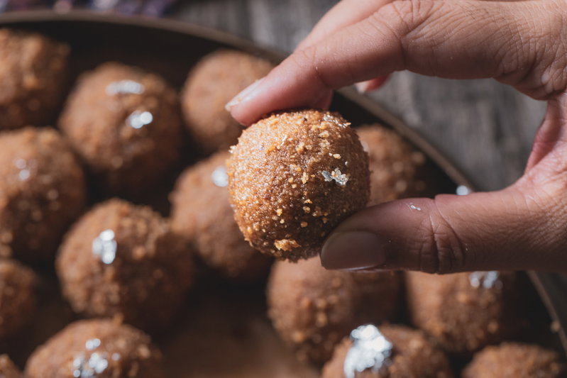 Puja holding out a choorma ladoo.